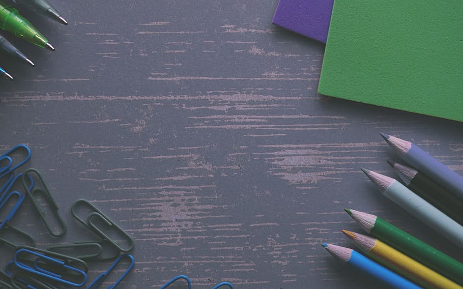assorted-color pencils near cardboards, clips, colour pencils
