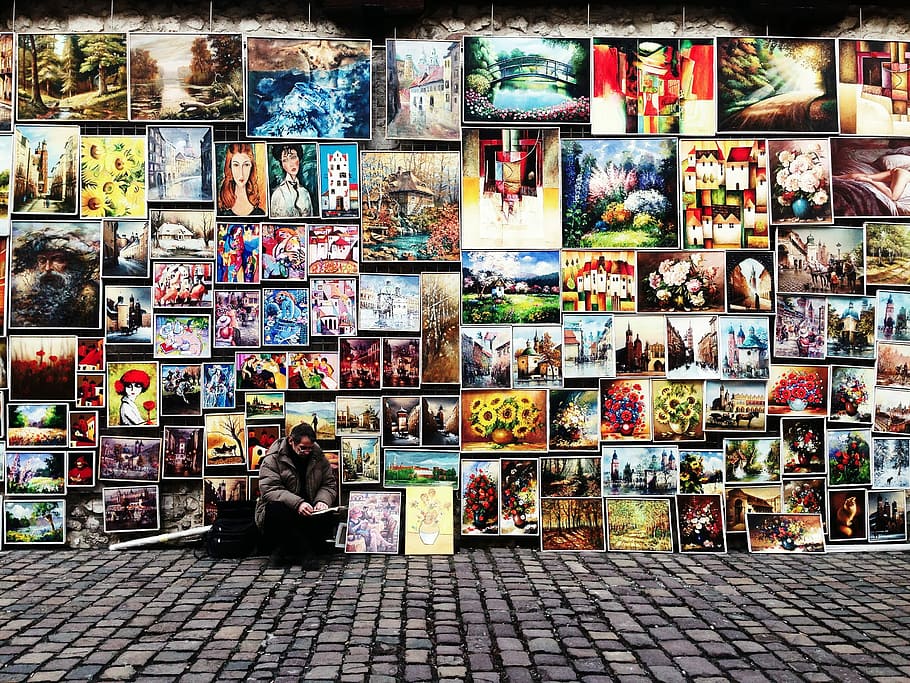 man sitting beside painting lot, man sitting in front of assorted paintings, HD wallpaper