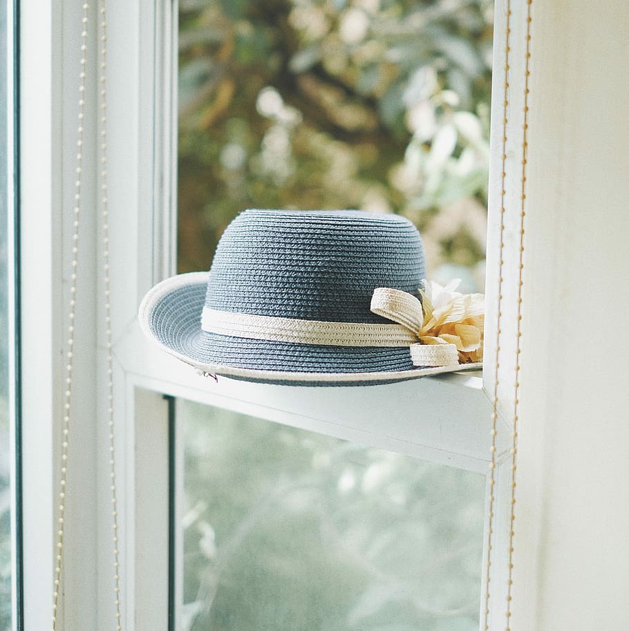 grey knitted hat on window, blue and white sun hat with flower accent placed on sash window HD wallpaper