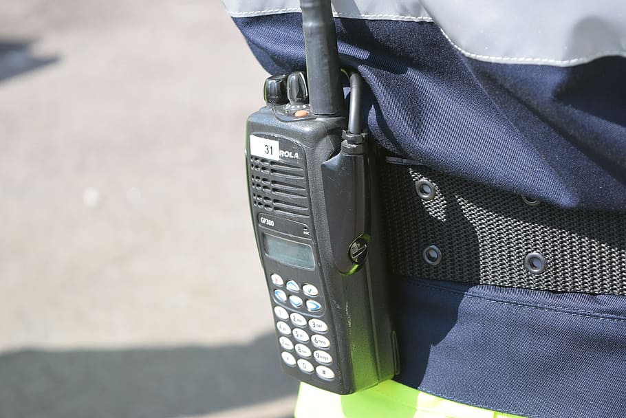 person wearing gray two-way radio at daytime, walkie talkie, emergency