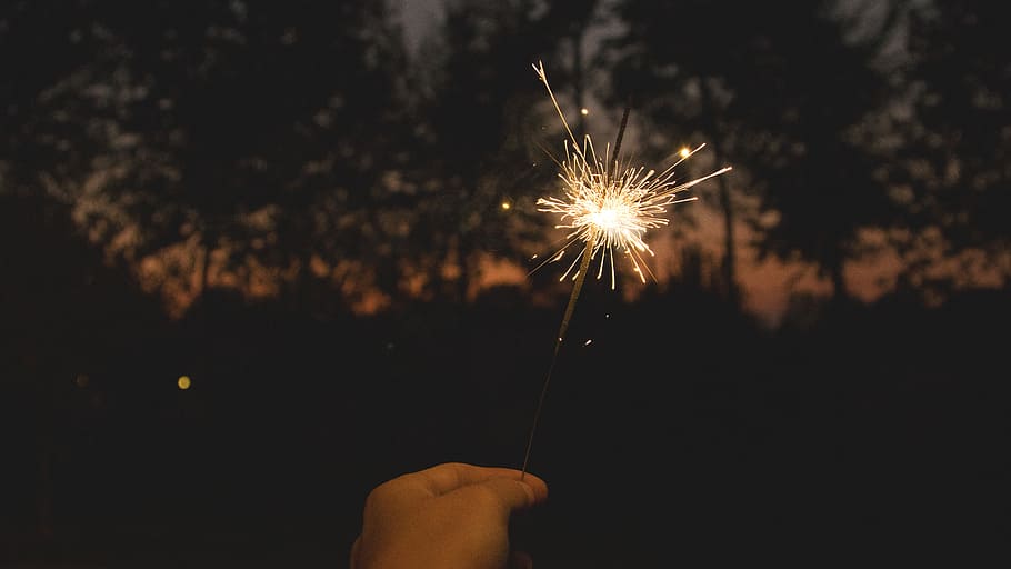 person holding sparkler, person holding sparkler in dark room HD wallpaper