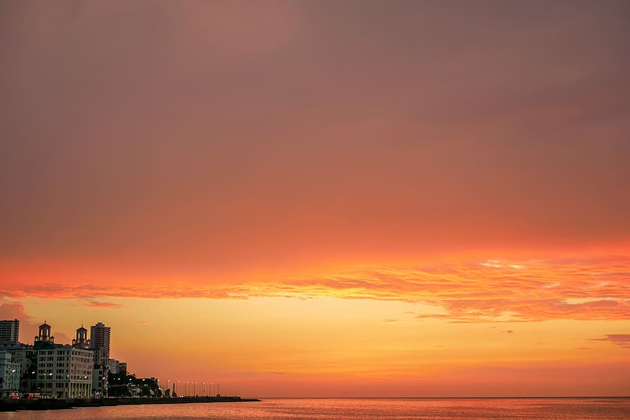 buildings under sunset, high rise buildings, orange, coast, sea HD wallpaper