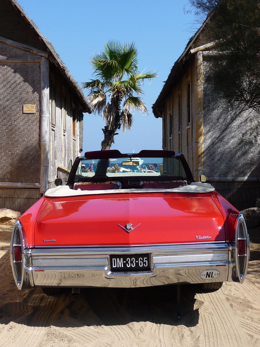 classic red Chevrolet convertible vehicle with DM-33-65 license plate parked infront of wooden buildings at daytime HD wallpaper