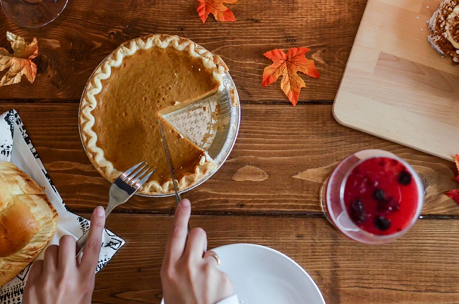 person holding table knife about to slice pancake, person slicing cake on table HD wallpaper