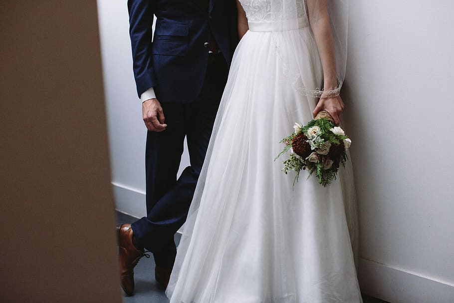 Lost in love, man in blue suit standing beside woman wearing bridal gown holding bouquet of flower, HD wallpaper