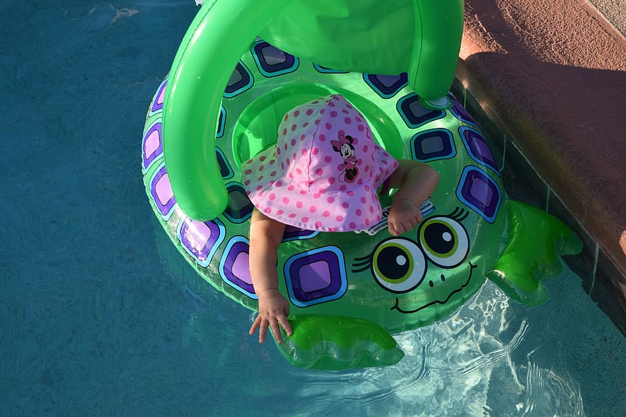 reaching, baby in green floater on pool, swimming pool, child