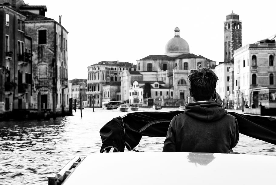 grayscale photo of man standing on boat, italy, venice, channel