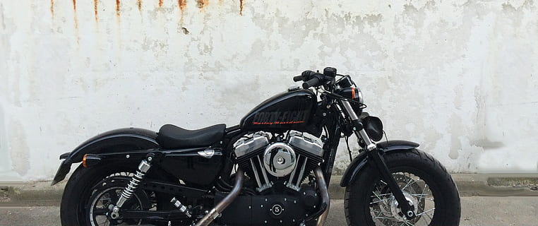 black cruiser motorcycle beside white wall, harley davidson HD wallpaper