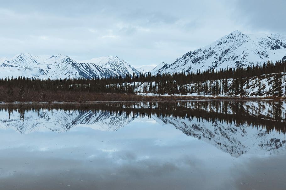 body of water surrounded by mountains under blue sky during daytime, snow caps mountain reflecting on body of water HD wallpaper