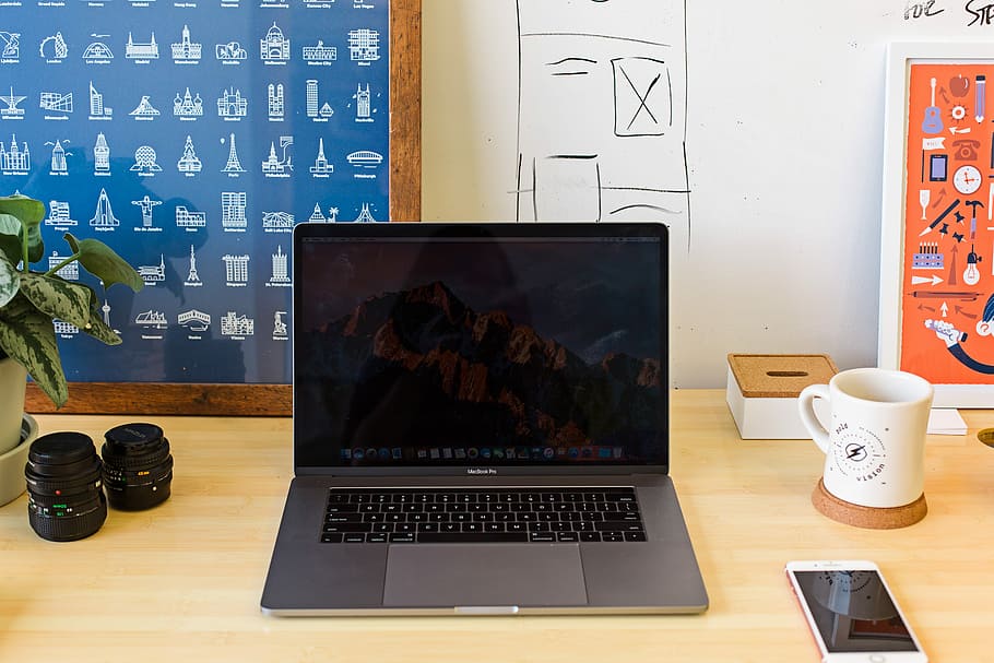 Macbook Pro on table near white mug and PRODUCT RED iPhone, MacBook Pro on table HD wallpaper