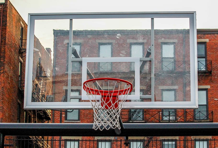 white and clear glass basketball hoop with board near brown concrete building
