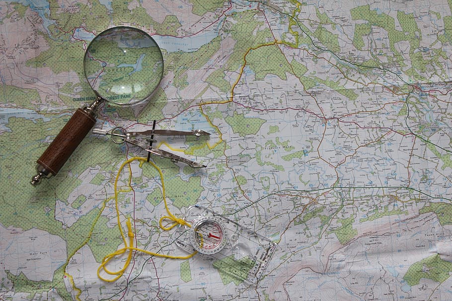 photo of magnifying glass and ruler on map, travel, compass, orienteering