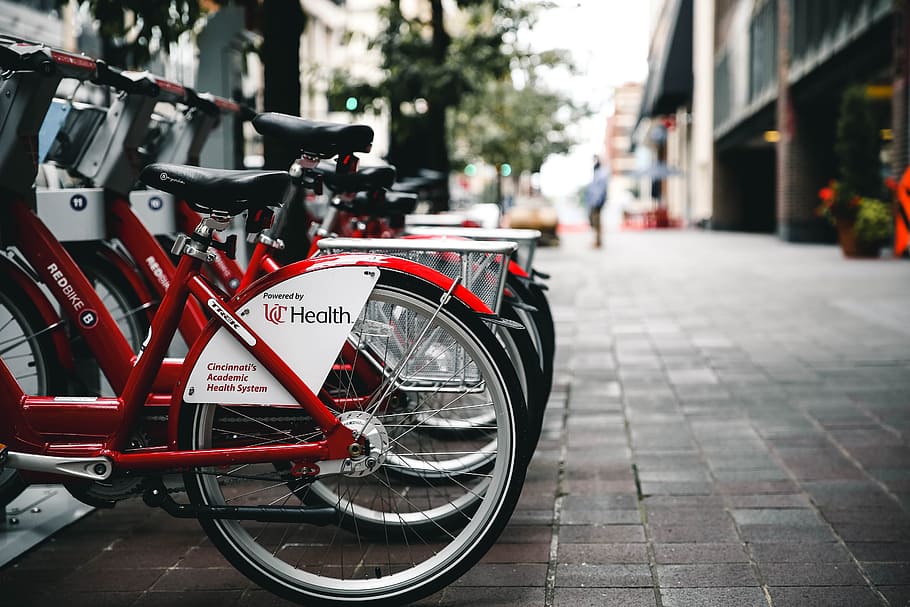 red bicycles parked besides building at daytime, red bicycle lot in parking space HD wallpaper