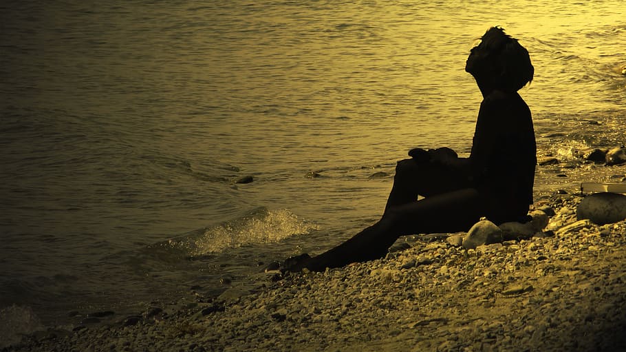 silhouette of person sitting on seashore, sonnenanbeterin, break