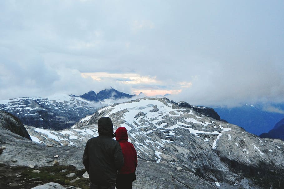 two person standing near cliff, two in hoodie jackets standing and overlooking on mountain HD wallpaper