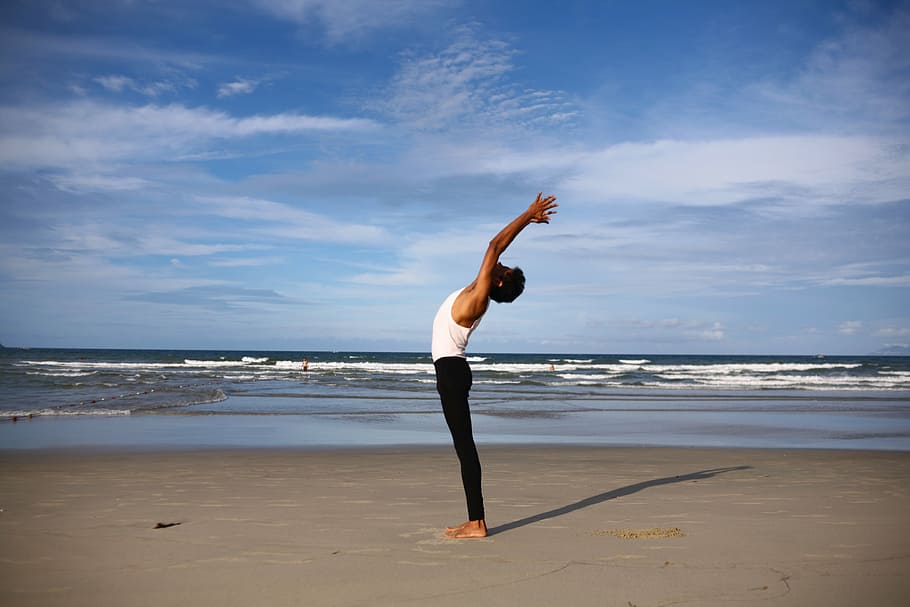 man wearing white tank top and black fitted pants, yoga, indian