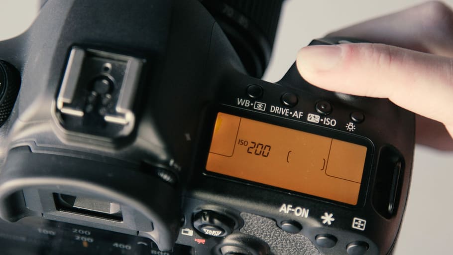 DSLR camera at 200 display, person holding black DSLR camera displaying 150 200 HD wallpaper
