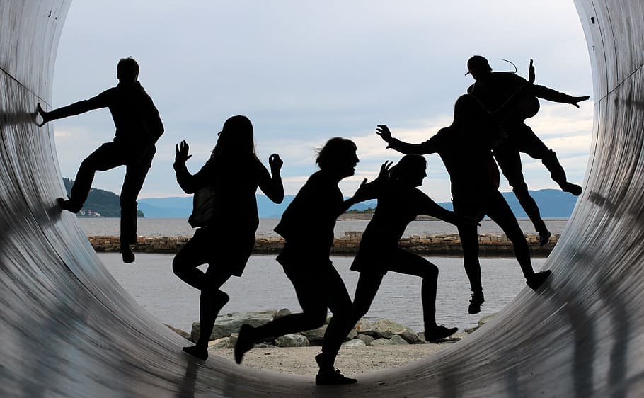 silhouette of people sliding on tunnel during daytime, friendship