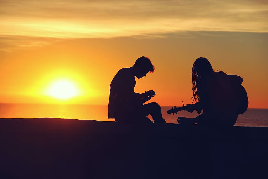 silhouette of man and woman playing guitars, silhouette of man and woman playing guitar during sunset