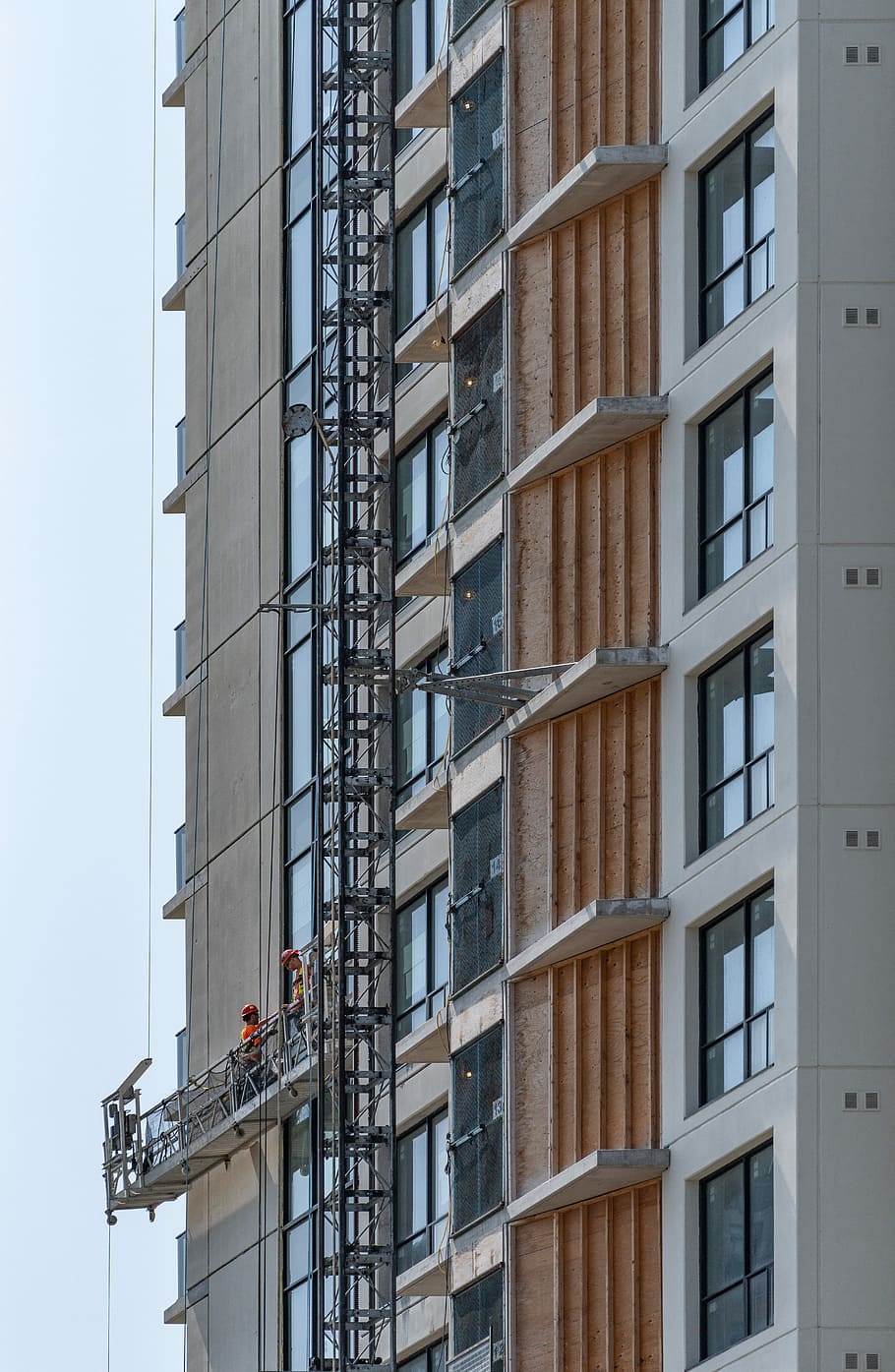 two persons on cleaning buildings window, gray and brown high-rise building view during daytime HD wallpaper