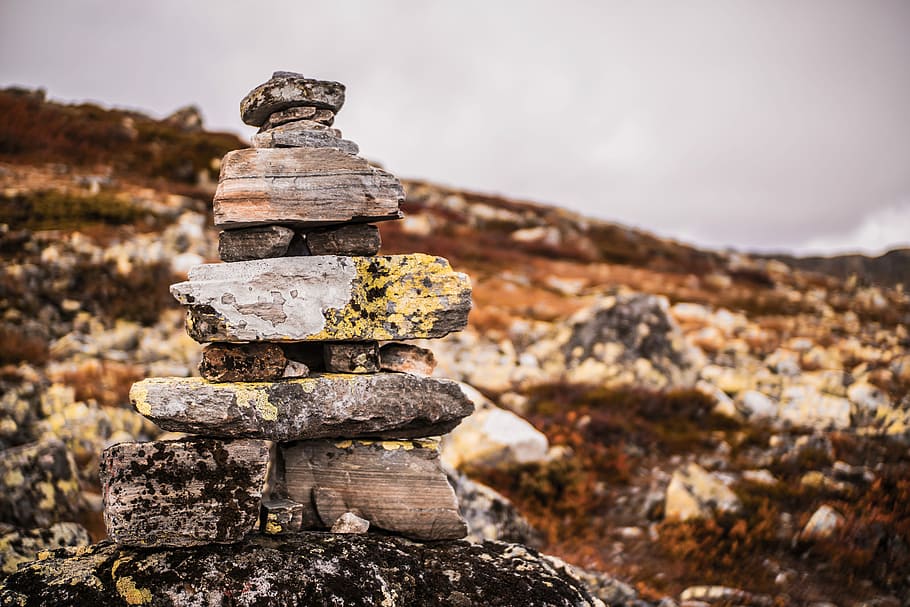gray stacked rocks on a mountain, selective focus photography of gray cairn HD wallpaper