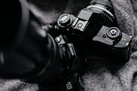 focus photography of two DSLR cameras, close-up photo of black Canon EOS 500 placed on black textile HD wallpaper