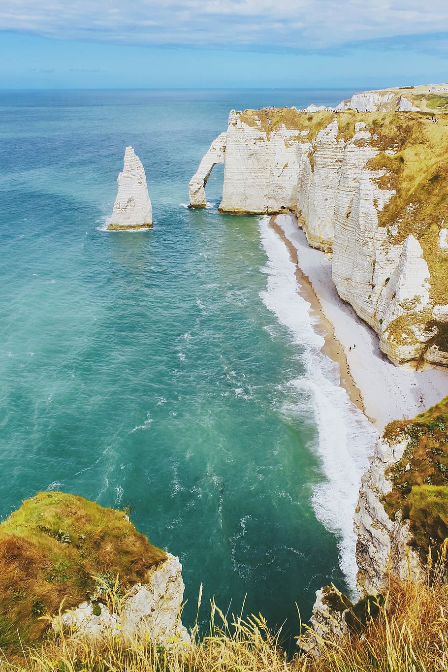 white cliff near body of water, photo of beige mountains beside body of water during daytime HD wallpaper