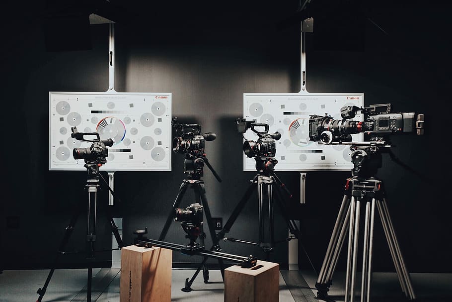 black video and DSLR cameras with tripods, four assorted black video recorders with tripods HD wallpaper