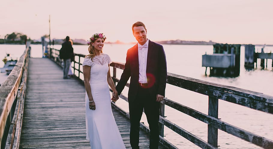 bride and groom standing on wooden dock near body of water, coupe standing on dock HD wallpaper