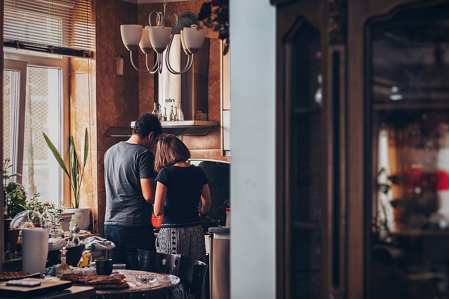 man and woman standing in front of gas range, man and woman cooking at the kitchen HD wallpaper