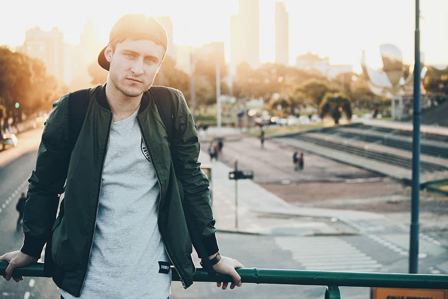 man sitting on railings, man standing on bridge, male, jacket HD wallpaper
