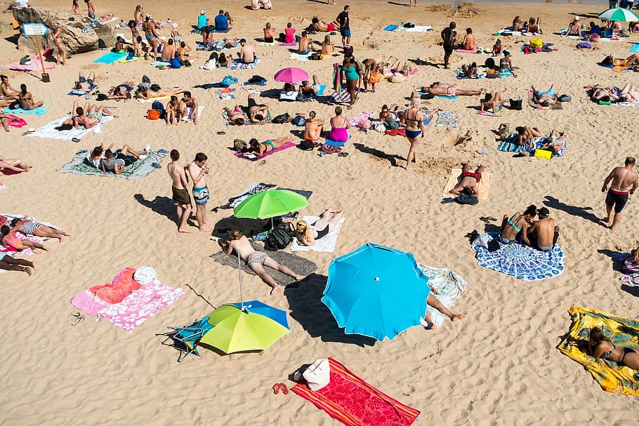 people on sand, bird's-eye view of people on beach, aparsol, sunbathing