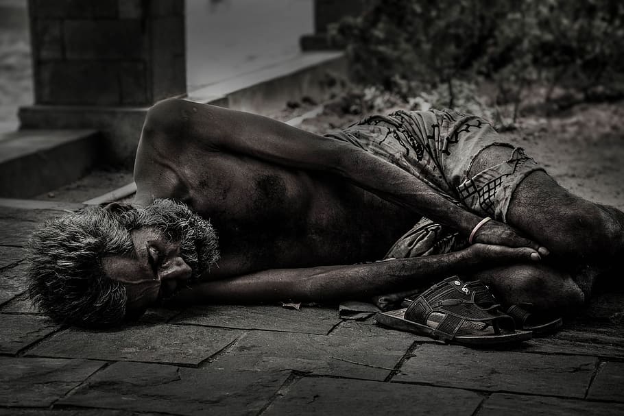 grayscale photo of man sleeping on floor near grass, people, homeless
