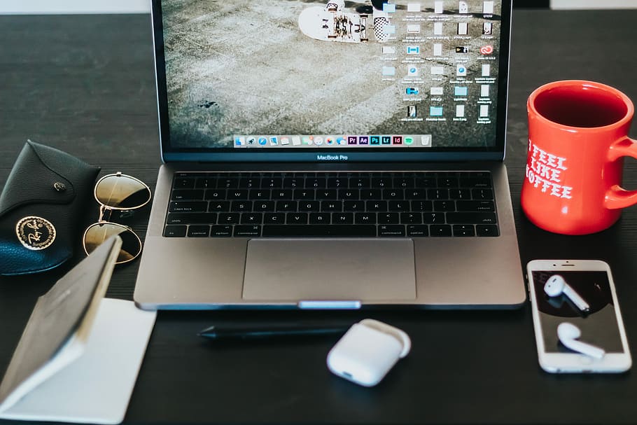 MacBook Pro turned on on black wooden table, switched on MacBook Pro near coffee mug HD wallpaper