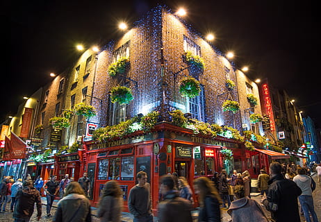 group of people walking on street in front of red lighted building HD wallpaper