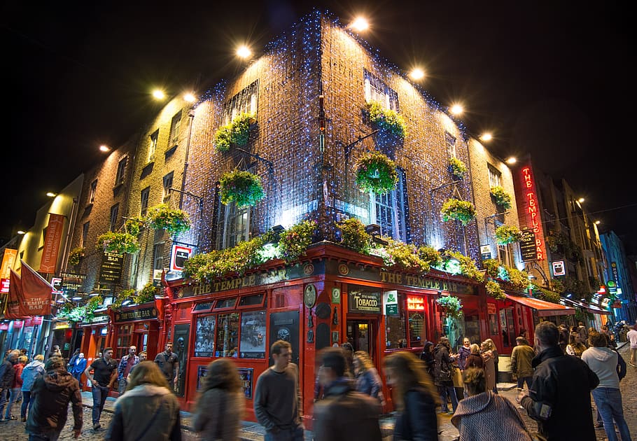 group of people walking on street in front of red lighted building HD wallpaper