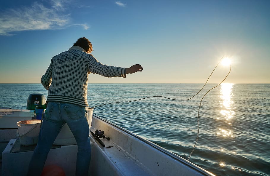 man standing on boat throwing rope on water, person standing on motorboat HD wallpaper