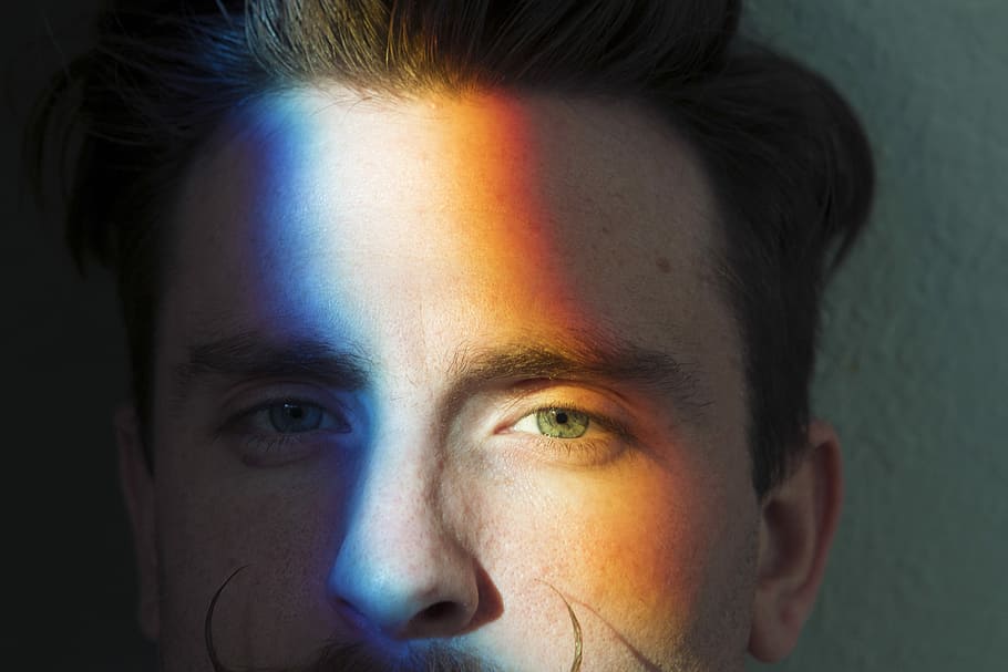 closeup photo of man's face with light reflections, man's face with blue, white, and orange lights HD wallpaper