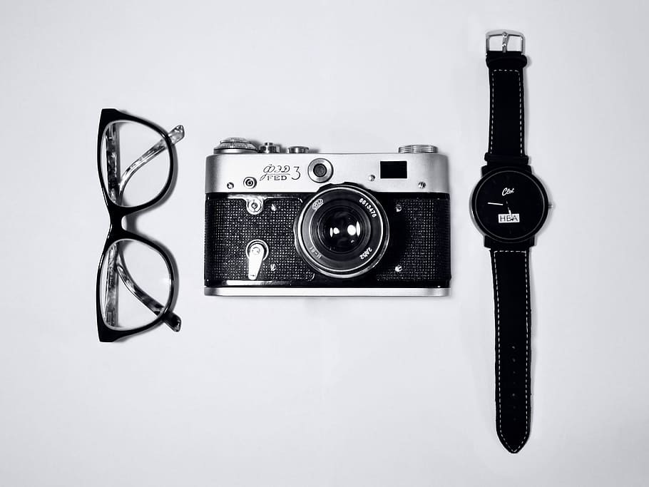 black and silver camera; eyeglasses with black frames; black analog watch, camera in the middle of eyeglasses and wristwatch HD wallpaper