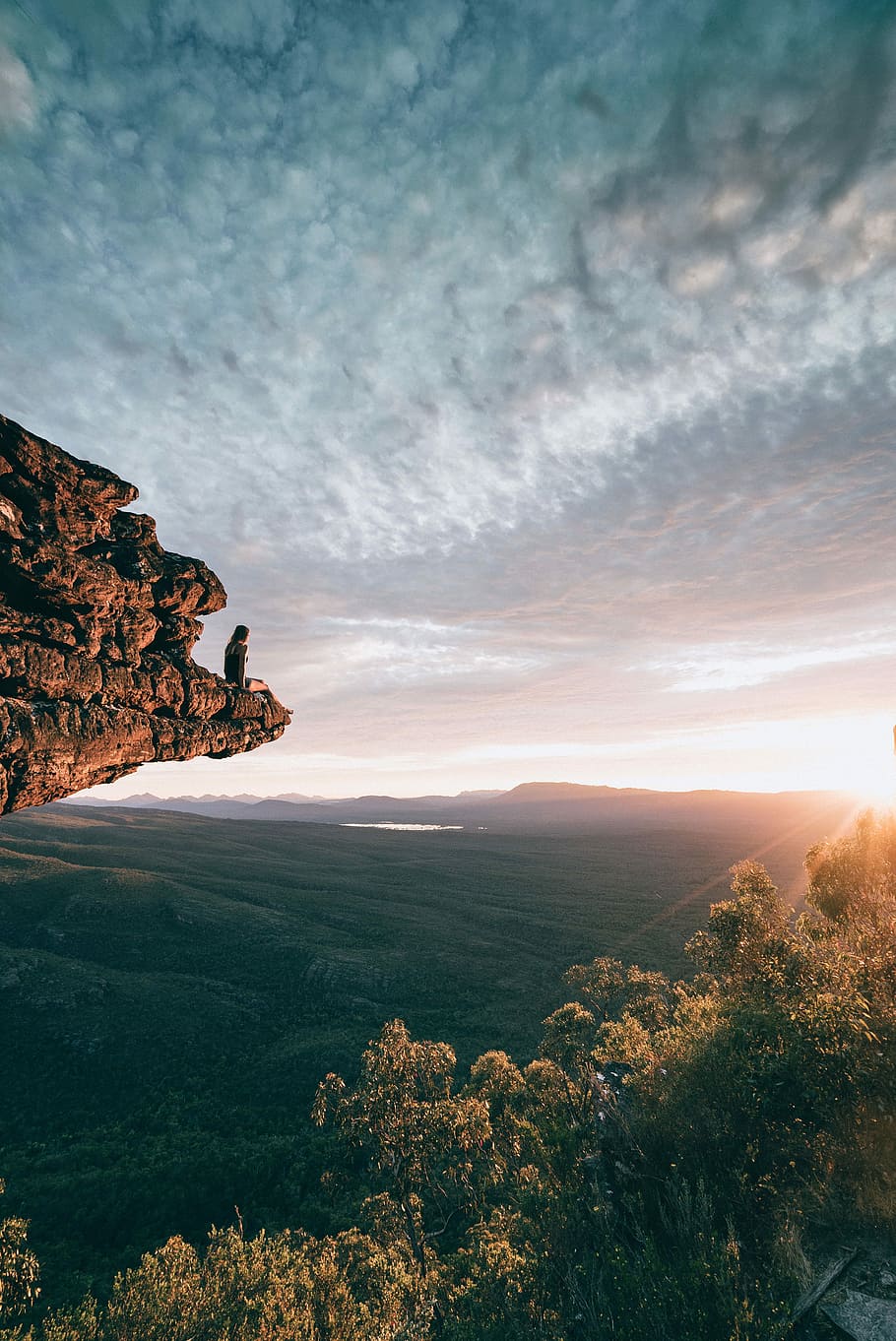 man sitting on mountain rock, person sitting on rock monolith HD wallpaper