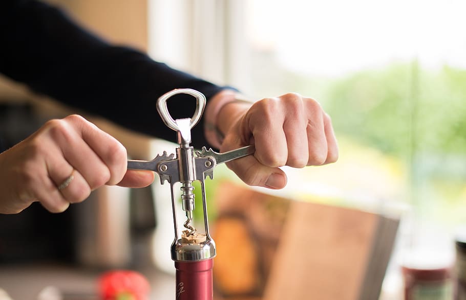 person holding gray stainless steel wine cork opener, Bottle