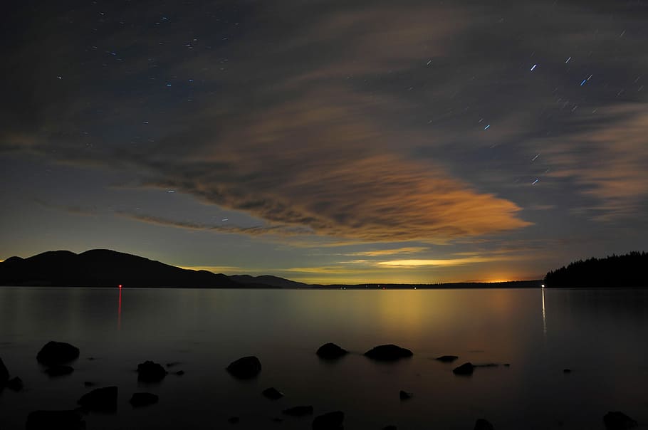 body of water during nighttime, silhouette photography of island HD wallpaper