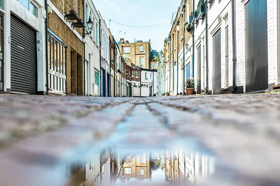 low angle view photography of brown pathway between hoses, gray concrete road between buildings during daytime HD wallpaper