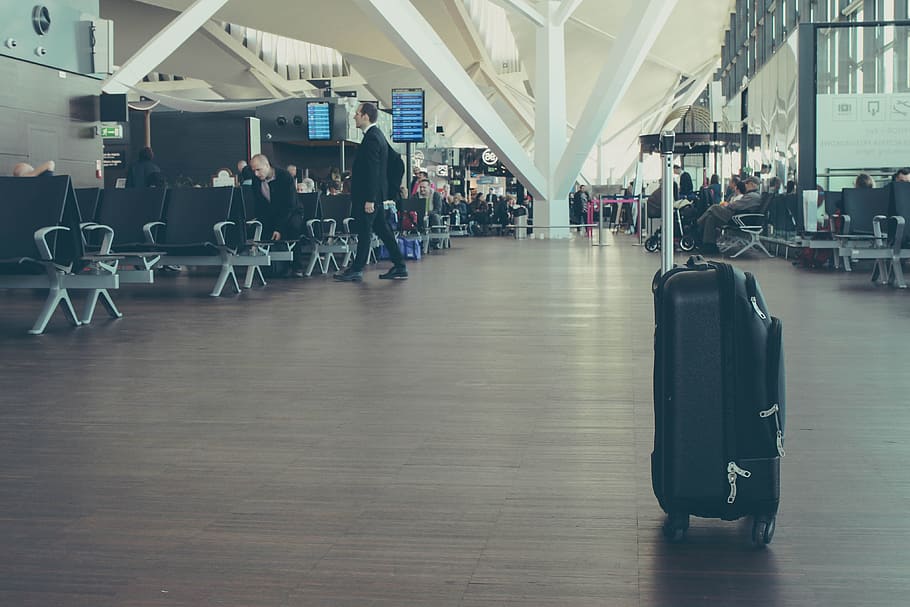 unattended black luggage inside airport, black softside luggage inside of airport