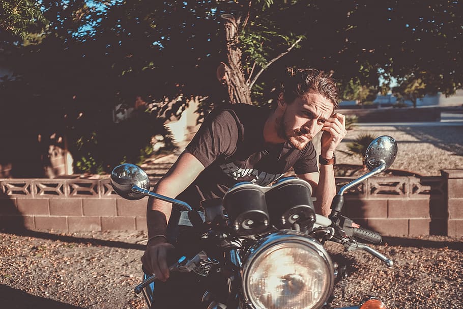 man riding on motorcycle looking at the mirror, man riding motorcycle outdoors HD wallpaper