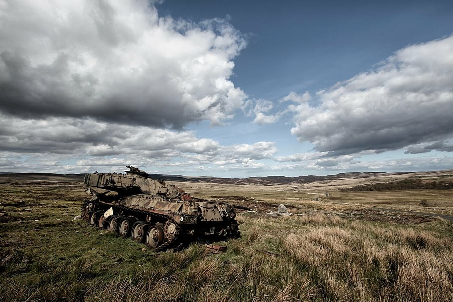 photo of brown military tank parked on grass during daytime, war