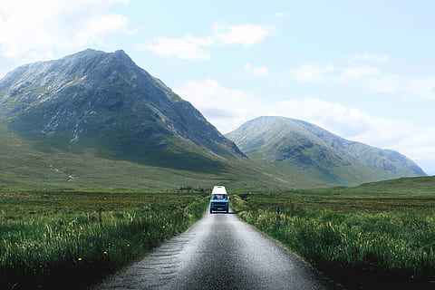 blue vehicle passing through grass field, landscape photography of vehicle on freeway near mountain range HD wallpaper