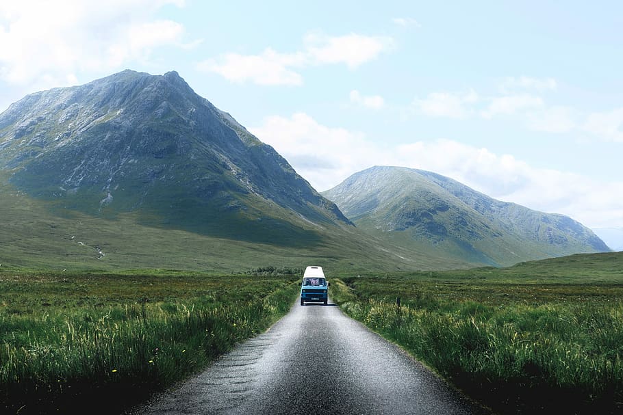 blue vehicle passing through grass field, landscape photography of vehicle on freeway near mountain range HD wallpaper