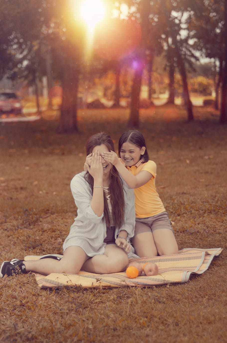 Two Women Sitting on Brown Picnic Mat during Sunset, adolescence