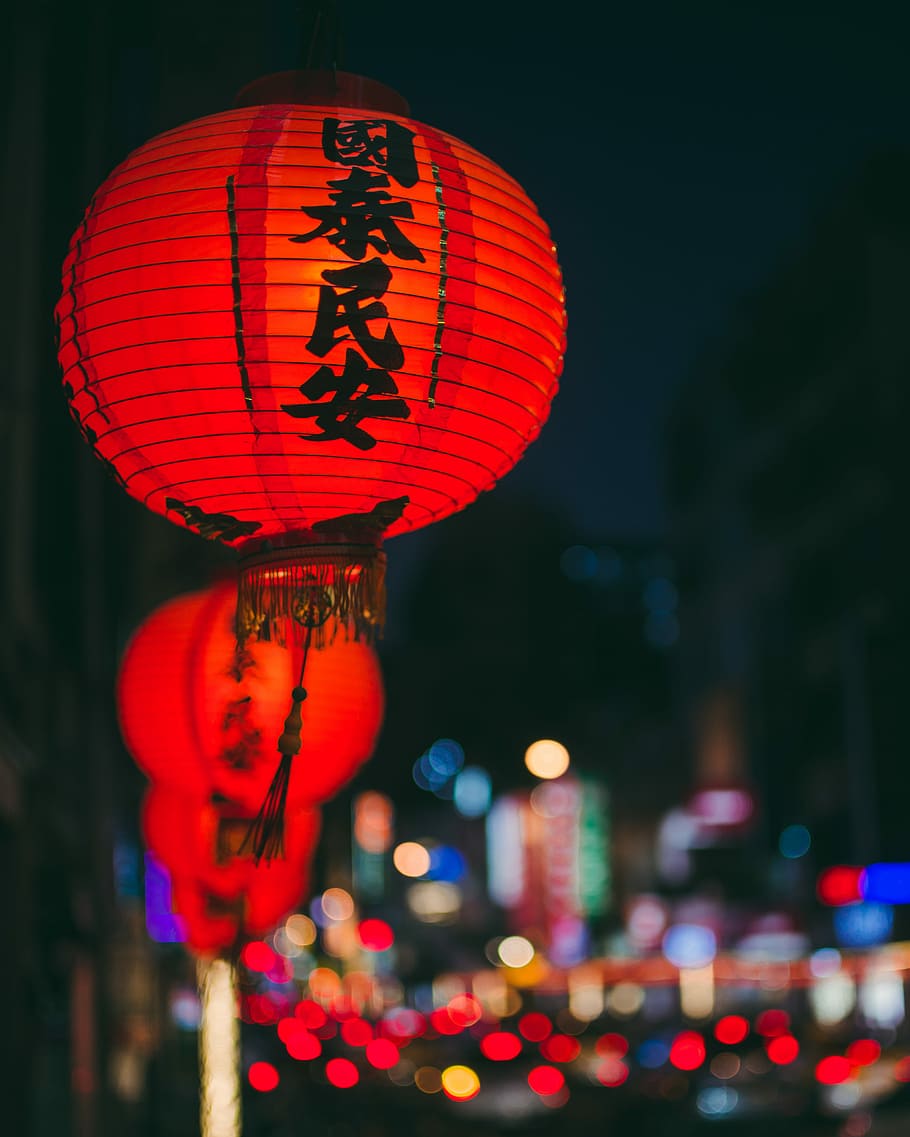 lit red Chinese lanterns during nighttime, selective focus photography of kanji script-printed oil paper lantern with fringe